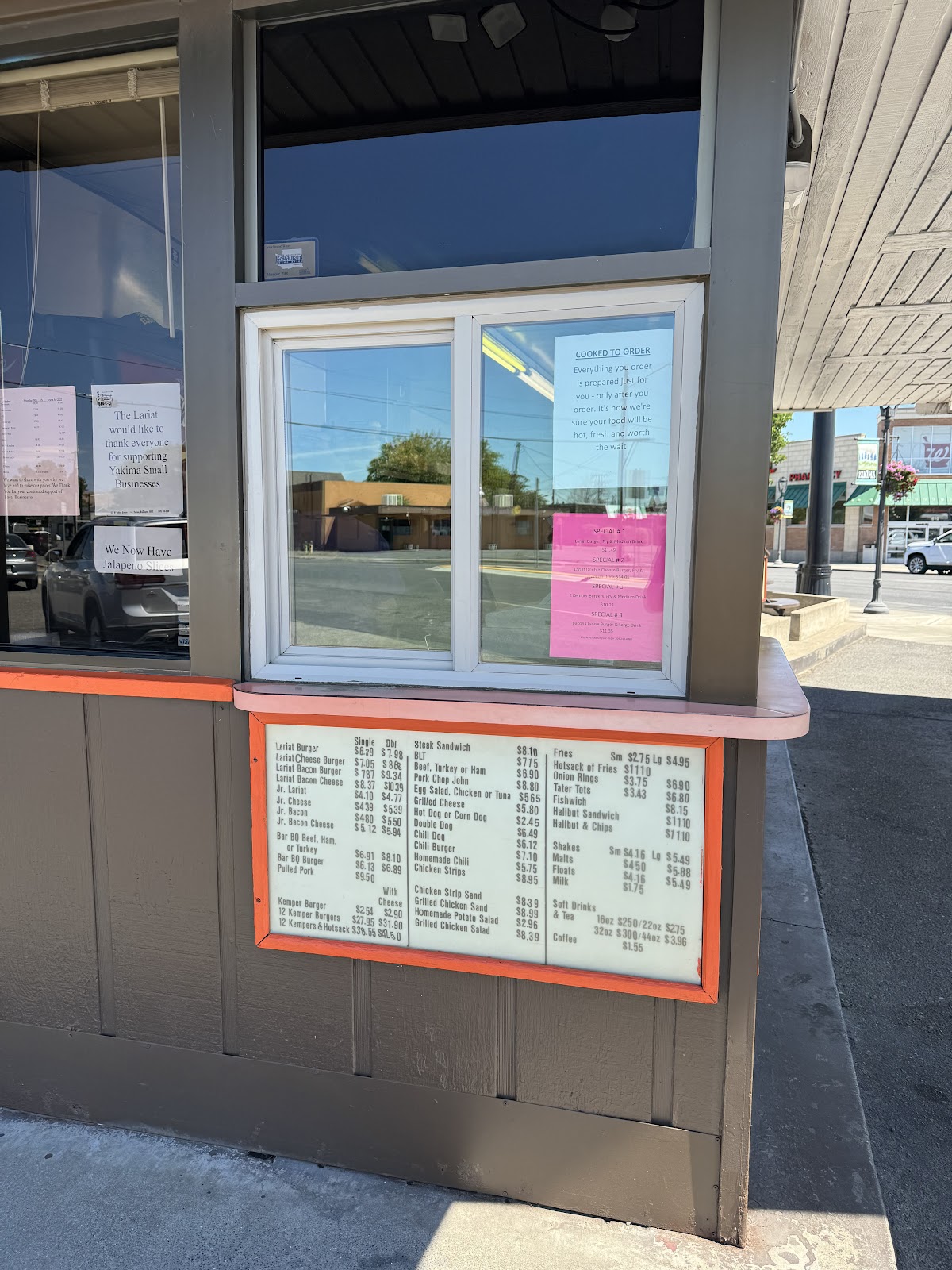 The walk-up window at Lariat Bar-B-Q with the cooked-to-order sign and hand-lettered menu board